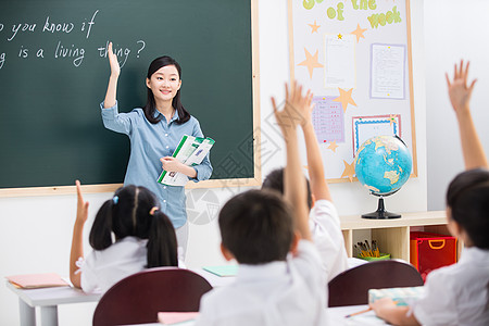 小学生女生和书黑板亚洲表现积极老师和小学生们在教室里背景