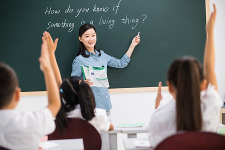 小朋友上课举手老师和小学生们在教室里背景