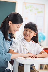 家教老师在指导小学女生学习图片