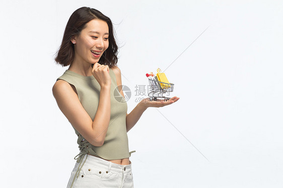 20多岁纯洁青年人青年女人手托着购物车图片
