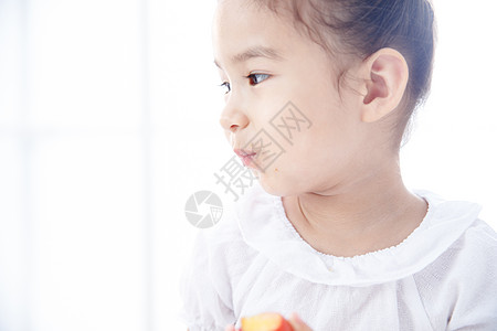 吃苹果表情可爱的小女孩在吃水果背景