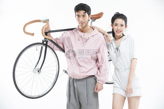 影棚拍摄两个人侧面视角青年情侣骑自行车图片