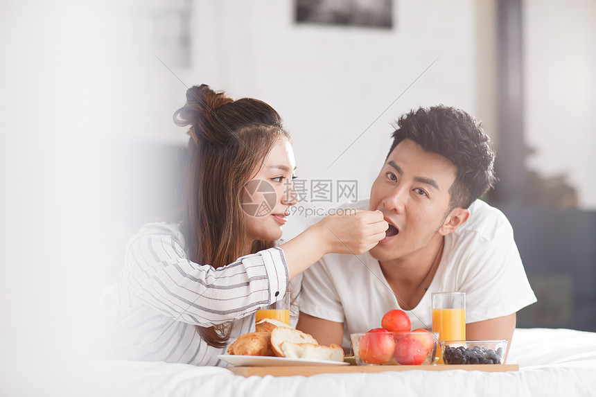 在床上吃早餐的情侣图片