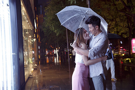 下雨天撑伞下雨天夜里一起逛街的情侣背景