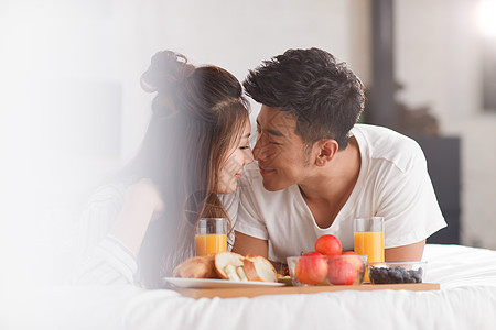 青年情侣在床上吃早餐图片