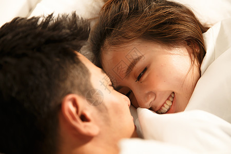 水平构图放松亲密的青年情侣在床上睡觉图片