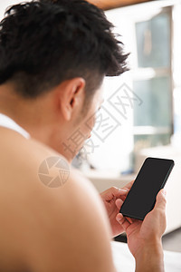 幸福享乐无忧无虑青年男人在卧室玩手机图片