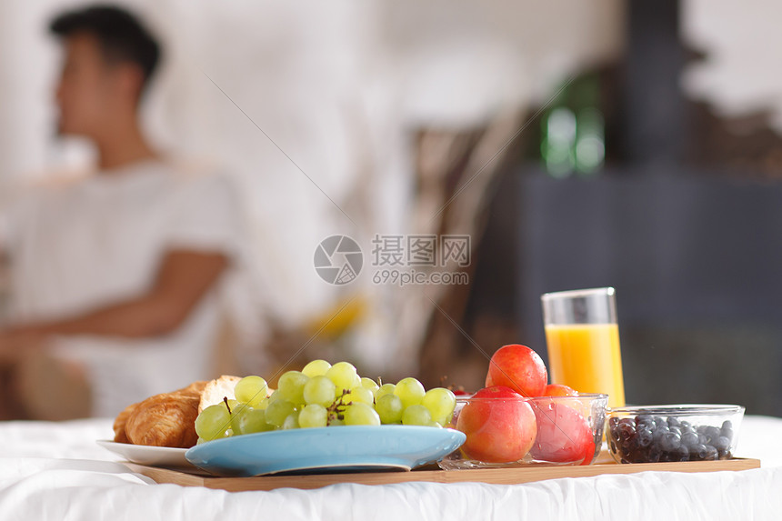 青年情侣在床上吃早餐图片