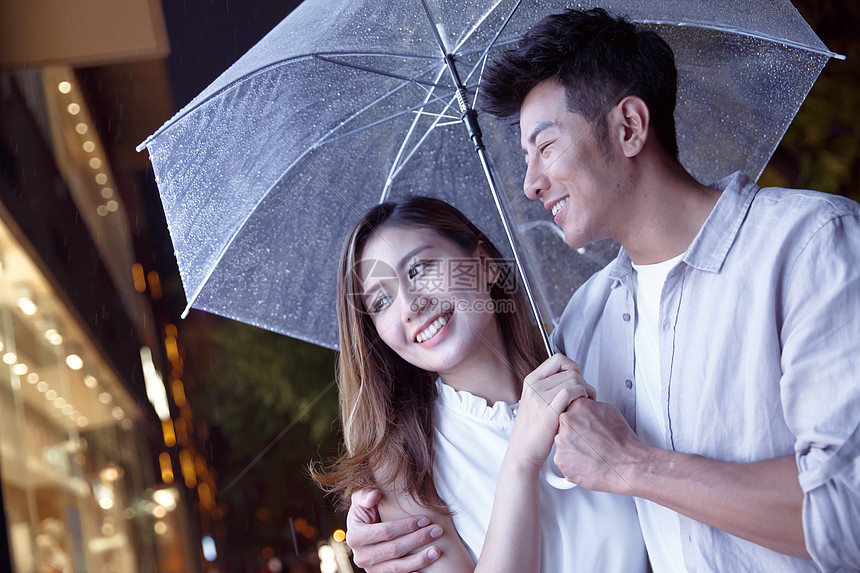 下雨天夜里一起逛街的情侣图片