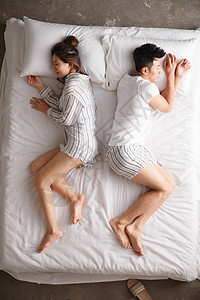 舒适深情的亚洲人青年情侣在床上睡觉图片