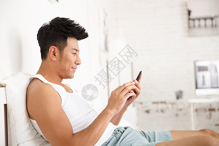 床智能手机仅成年人青年男人在卧室玩手机图片