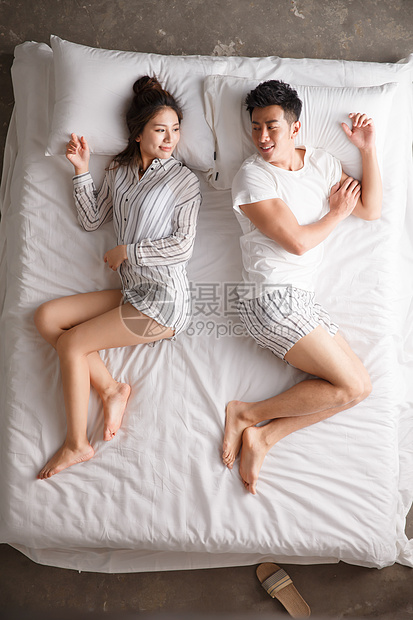 享乐成年人全身像青年情侣在床上睡觉图片