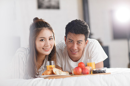 青年情侣在床上吃早餐图片