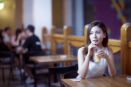 餐厅光效果白领青年女人在喝果汁图片