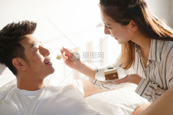 青年情侣面对面吃蛋糕图片