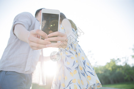 青年伴侣大半身男人青年情侣用手机照相图片