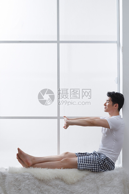 亚洲住宅内部户内青年男人坐在窗户旁边图片