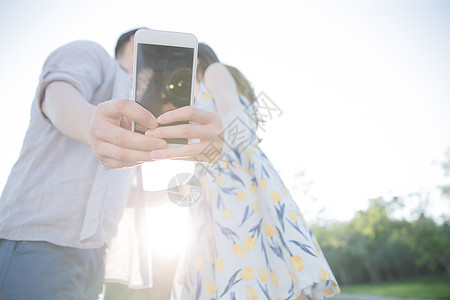 选择对焦日光家庭生活青年情侣用手机照相图片