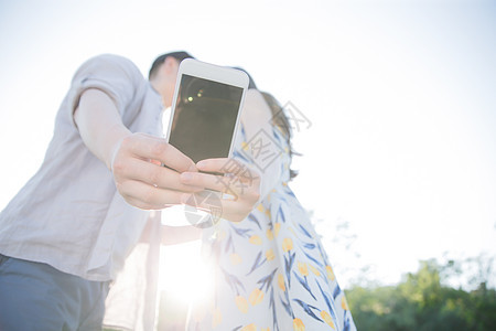 日光青年夫妇和谐青年情侣用手机照相图片
