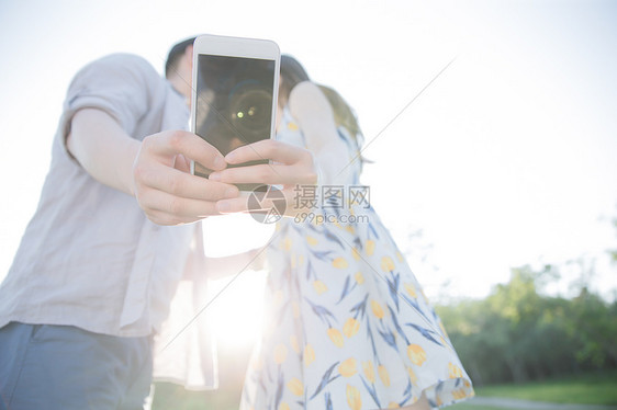 享乐青年情侣用手机照相图片