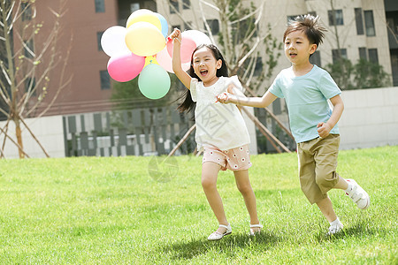 气球手牵手休闲活动快乐儿童在草地上玩耍图片