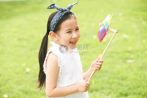 高举手臂可爱的儿童小女孩在户外玩耍图片