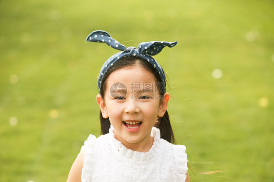 半身像高兴的发饰小女孩在户外玩耍图片