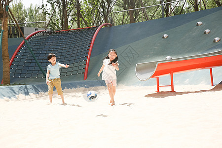 仅儿童幸福学龄前儿童儿童在沙子里踢球图片