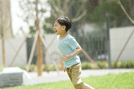 快乐幸福喷泉小男孩在户外玩耍图片