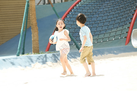 户外幸福男孩儿童在沙子里踢球图片