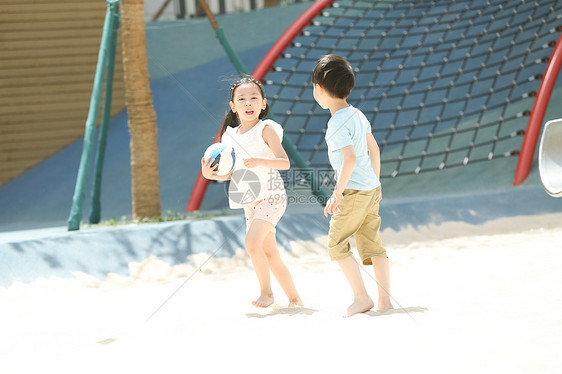 户外幸福男孩儿童在沙子里踢球图片