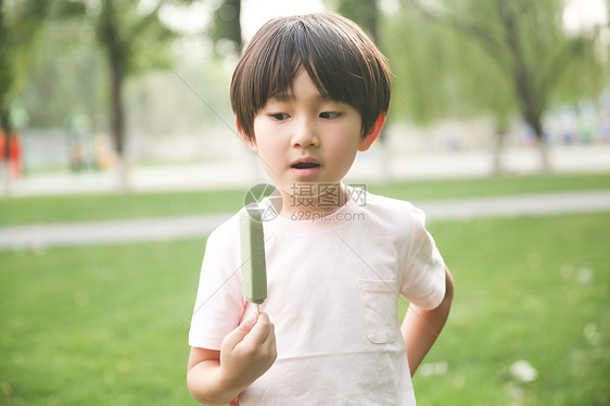 东方人可爱的冰淇淋小男孩吃冰棍图片