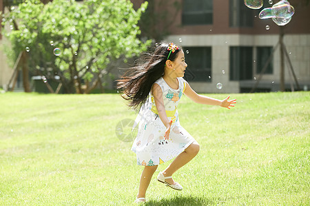 草地童年裙子小女孩在户外玩耍图片