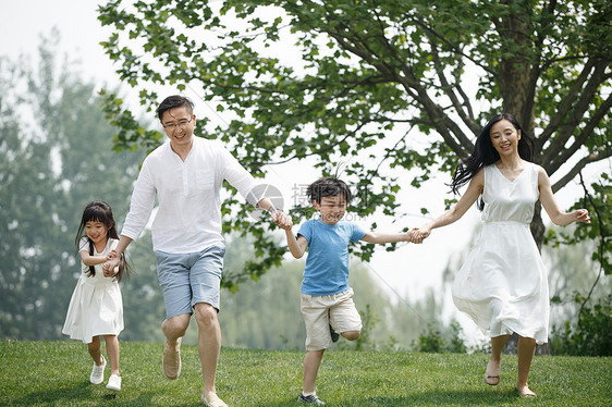 可爱的郊游30岁到34岁快乐家庭在草地上奔跑图片