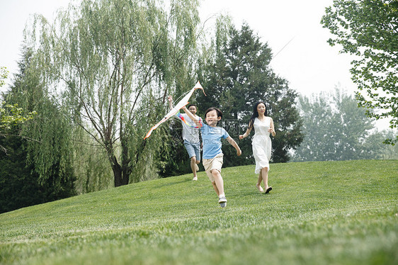 人25岁到29岁家庭一家三口在草地上奔跑图片