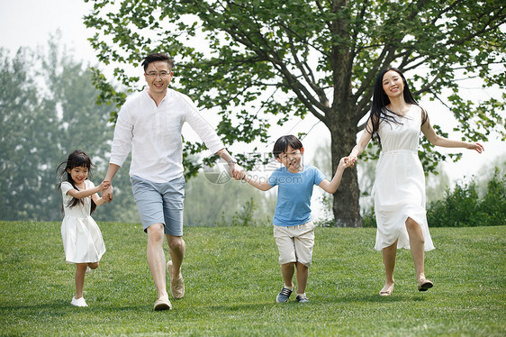 快乐家庭在草地上奔跑图片