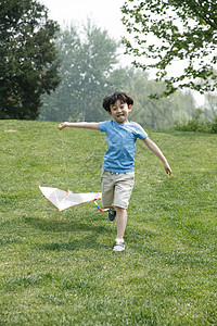 摄影垂直构图嬉戏的小男孩放风筝图片