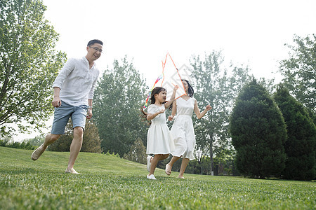 双亲家庭绿色童年一家三口在草地上放风筝图片