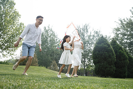 双亲家庭三个人学龄前儿童一家三口在草地上放风筝图片