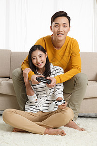 摄影青年伴侣看青年情侣坐着沙发上玩游戏图片