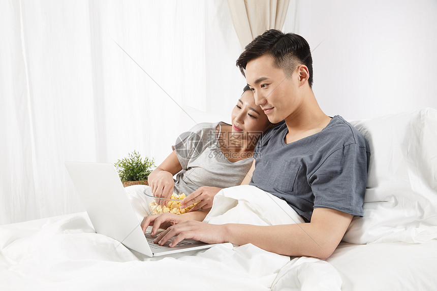 彩色图片相伴亚洲人青年情侣坐着床上看电脑图片