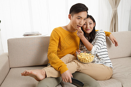 快乐享乐健康的青年情侣坐着沙发上看电视图片