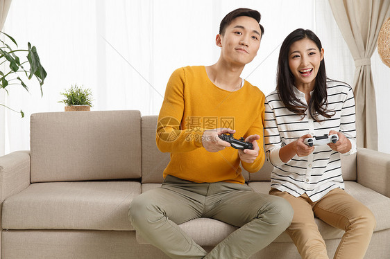 和谐满意女朋友青年情侣坐着沙发上玩游戏图片