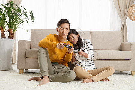 相伴白昼两个人青年情侣坐着沙发上玩游戏图片