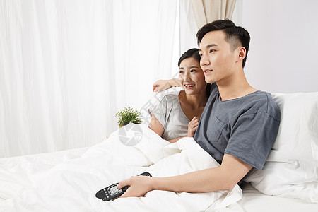 女人20多岁女朋友青年情侣坐着床上看电视图片