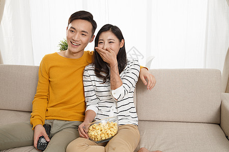 青年伴侣女人相伴青年情侣坐着沙发上看电视图片