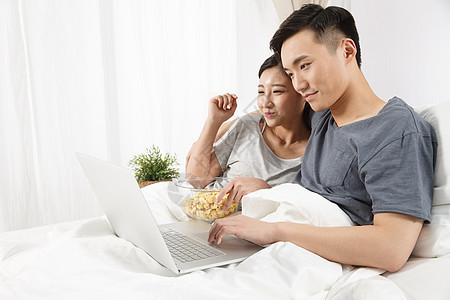 仅成年人彩色图片乐趣青年情侣坐着床上看电脑图片
