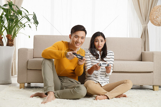 乐趣青年伴侣幸福青年情侣坐着沙发上玩游戏图片
