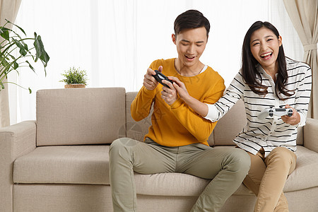 成年人青年人白昼青年情侣坐着沙发上玩游戏图片