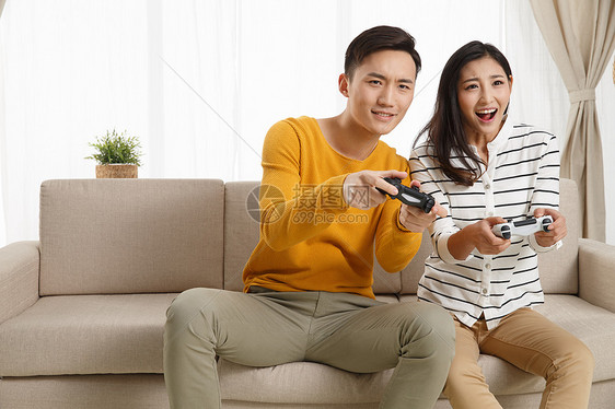 健康的客厅彩色图片青年情侣坐着沙发上玩游戏图片